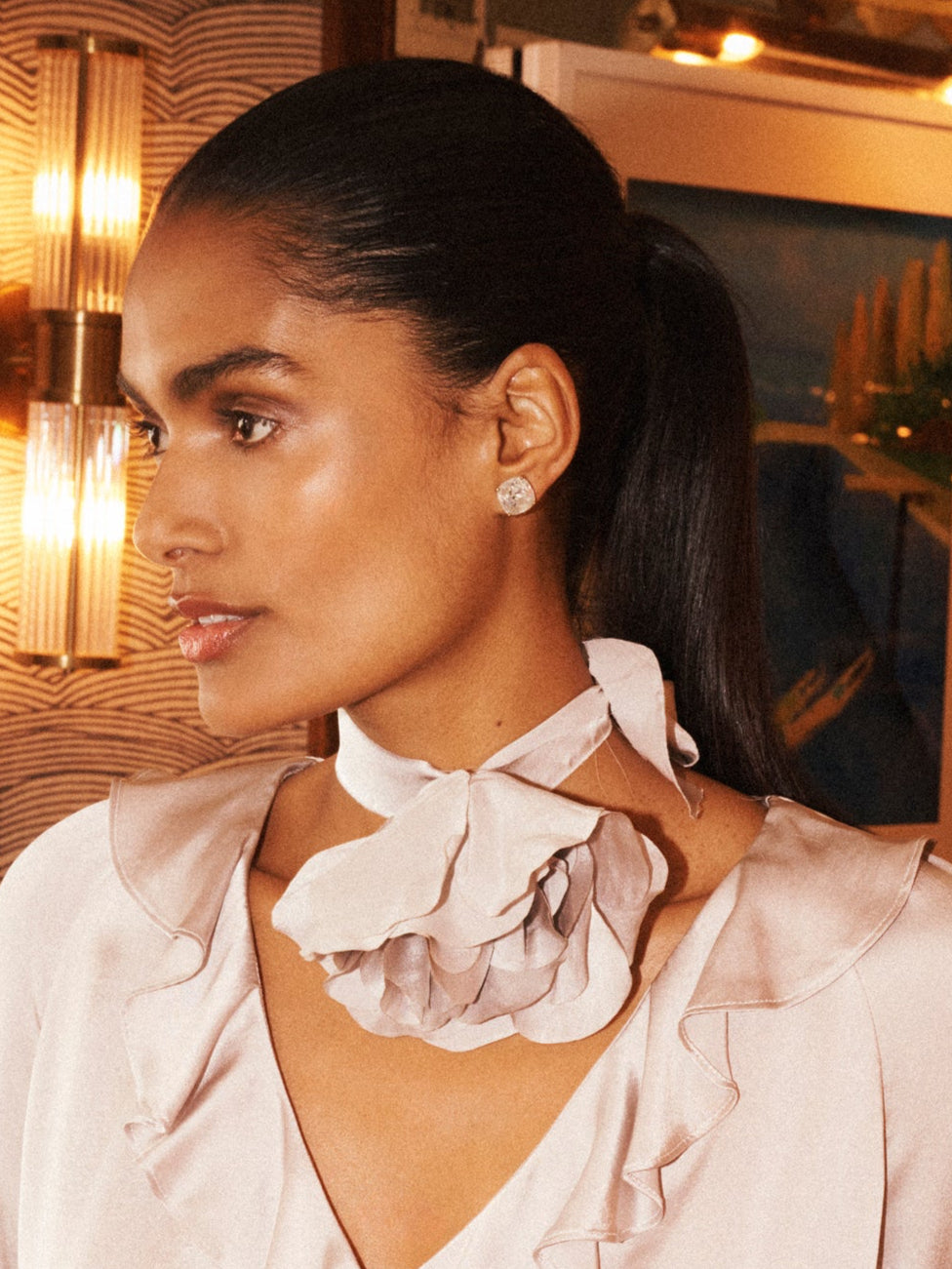 Woman wearing a white blouse with ruffled details in an indoor setting