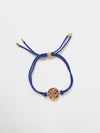 Gold bracelet with blue tassel