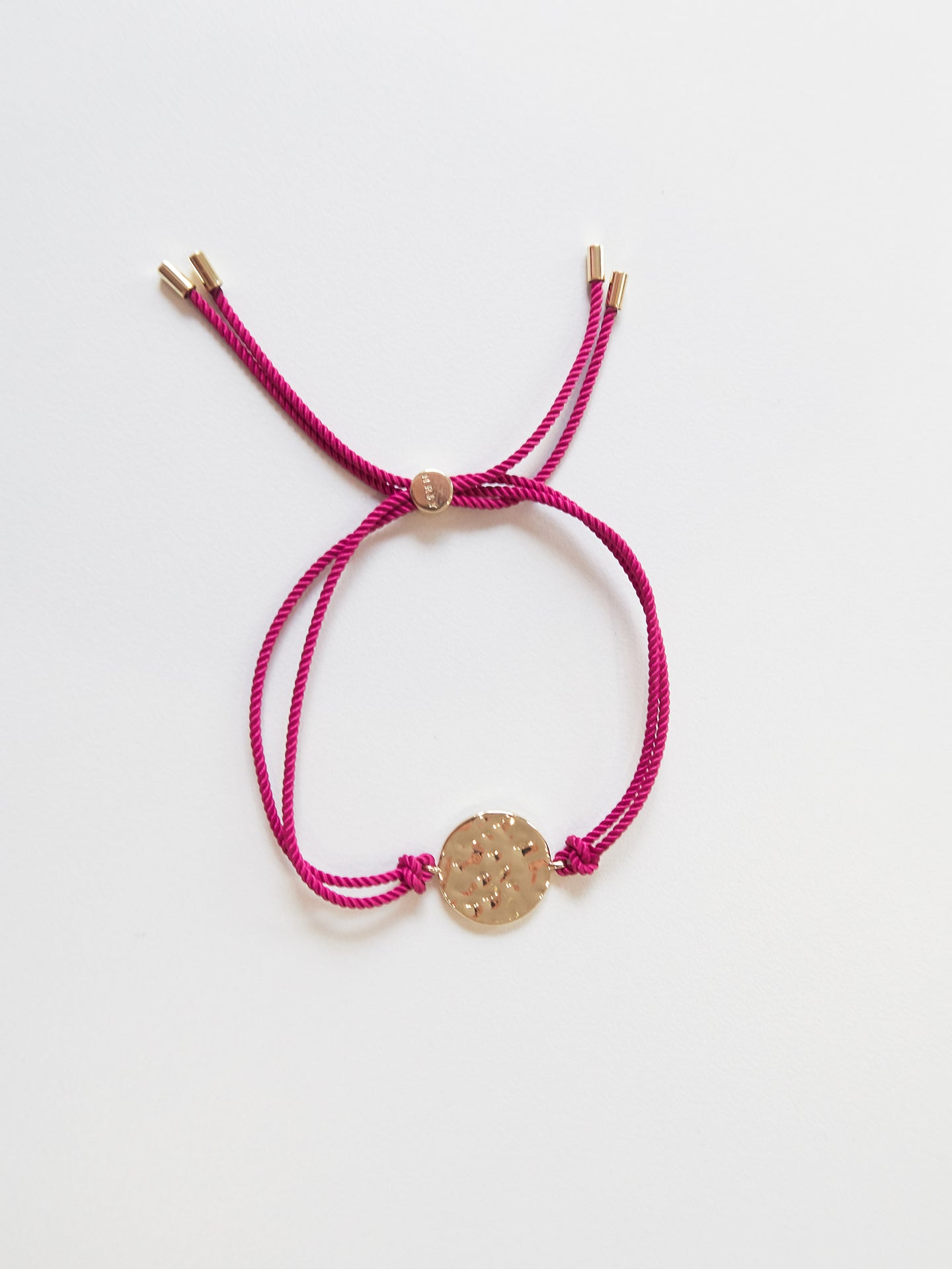 Gold bracelet with pink tassel